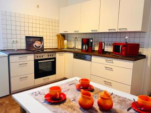 uma cozinha com pratos de laranja numa mesa em Ferienwohnung zur Schobse em Ilmenau