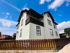 uma casa com uma cerca de madeira em frente em Ferienwohnung zur Schobse em Ilmenau