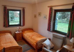 um quarto com 2 camas, um sofá e 2 janelas em M042 Teach Trianlair em Toormakeady