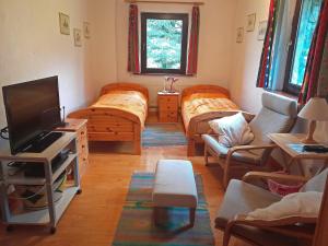 uma sala de estar com 2 camas e uma televisão de ecrã plano em M042 Teach Trianlair em Toormakeady