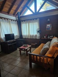 a living room with a couch and a tv at Cabañas Huinca Mapu - Sierra de los Padres in Sierra de los Padres