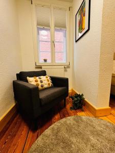 a living room with a chair and a window at Apartment II für 4 Aalen I Wlan I Netflix in Aalen