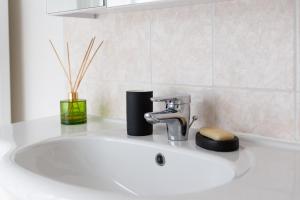 a bathroom sink with a faucet on top of it at L'Ecrin de charme Versaillais in Versailles