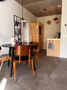a kitchen and dining room with a table and chairs at Gastenverblijf 'tsiishokje' in Lioessens