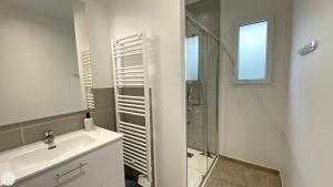 a white bathroom with a sink and a shower at Appart 'Hôtel BreakIsleBed Limoges CHU & Fac Médecine Pharma à Pied parking gratuit in Isle +29 photos