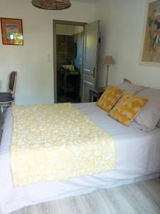 um quarto com uma grande cama branca com almofadas amarelas em Chambre d hotes de charme em Vernon