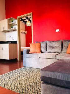 a living room with a couch and a red wall at Renty Paraguay in Asuncion