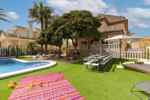 a backyard with a pool and a table and a house at Seaside Elegance by Fidalsa in La Manga del Mar Menor