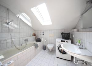 a bathroom with a washing machine and a sink at Ferienwohnungen Roseninsel & Perle in Feldafing +34 photos