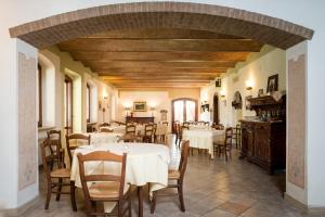 un comedor con mesas y sillas blancas en Terra Umbra Hotel, en Narni