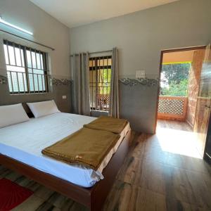 sypialnia z dużym łóżkiem i balkonem w obiekcie Dakshinamurthi Beach Stay w mieście Gokarna