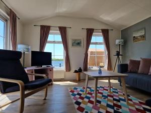 a living room with a table and a couch at Chalet in Lauwersoog