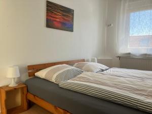 a bed in a bedroom with a picture on the wall at Festhaus Stocksberg - Herberge 1881 in Stocksberg