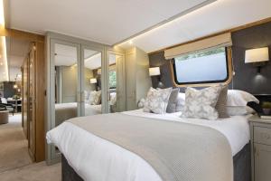 una camera da letto con un grande letto bianco e una finestra di Luxus Hausboot am Pichelssee - Madame President a Berlino