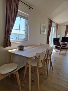 een eetkamer met een tafel en stoelen en een raam bij Chalet in Lauwersoog