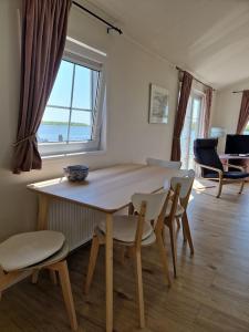 een tafel en stoelen in een kamer met een raam bij Chalet in Lauwersoog
