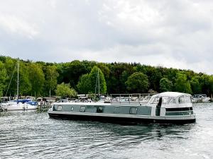 un barco está atracado en un cuerpo de agua en Luxus Hausboot am Pichelssee - Madame President en Berlín