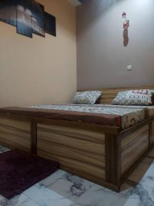 ein Schlafzimmer mit einem Holzbett in einem Zimmer in der Unterkunft Cool meuble 2 in Ouagadougou