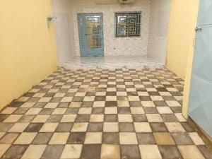 a room with a checkered floor and a blue door at Cool meuble 2 in Ouagadougou