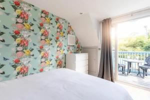 a bedroom with a bed with a floral wall at 2 bed 2 bathroom house on Little Petherick Creek in Little Petherick