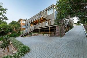 a large house with a walkway in front of it at The Milkwoods Luxury Living in Mossel Bay