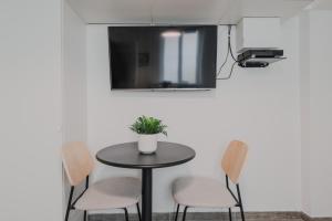 a small table with chairs and a tv on a wall at CMG Batignolles - Lechapelais II in Paris