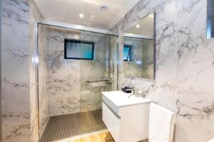 a white bathroom with a shower and a sink at The Milkwoods Luxury Living in Mossel Bay +45 photos
