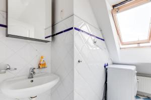 La salle de bains blanche est pourvue d'un lavabo et d'un miroir. dans l'établissement Cozy & Quiet Center Attic with Castle view - vtuB, à Prague
