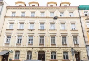 un grand bâtiment avec de nombreuses fenêtres donnant sur une rue de la ville dans l'établissement Cozy & Quiet Center Attic with Castle view - vtuB, à Prague