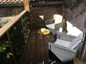 eine Terrasse mit 2 Stühlen und einem Tisch auf einer Terrasse in der Unterkunft Les chambres d'Ursule in Tartas