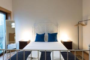 a bedroom with a white bed with blue pillows at GuestReady - Memories House - Art Quartier in Porto