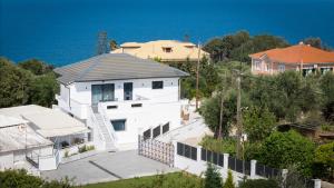 a white house with a grey roof and the ocean at Mare Vento II in Zakynthos