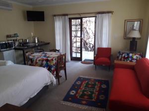 a hotel room with a bed and a kitchen and a living room at Springfontein Guesthouse in Springfontein