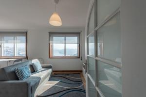 a living room with a couch and two windows at GuestReady - Porto Magic View in Vila Nova de Gaia