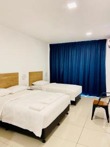 two beds in a room with blue curtains at BIG TREE HOTEL in Temerloh