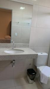 La salle de bains est pourvue d'un lavabo et de toilettes. dans l'établissement Lazzaru's Hotel, à Alexânia