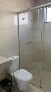 a bathroom with a toilet and a glass shower at Lazzaru's Hotel in Alexânia