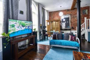 sala de estar con sofá y TV en Lushpads en Mánchester