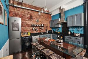 a large kitchen with a brick wall at Lushpads in Manchester
