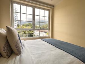 1 dormitorio con 1 cama y ventana grande en Prime Location Escazu Mountain View & Excellent for medical recovery en San Rafael