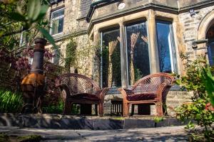 two wicker chairs sitting in front of a building at Crow Nest House in Hebden Bridge