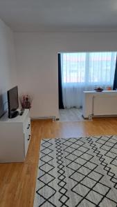 a white living room with a tv and a desk at Apartament Nicol in Drobeta-Turnu Severin