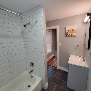 a bathroom with a white tub and a sink at Walk to Niagara Falls. Renovated 3 bed house! in Niagara Falls
