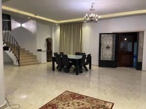 jadalnia ze stołem, krzesłami i schodami w obiekcie فيلا العائلة w mieście ‘Ezbet Sharikât Wardan