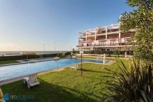 una piscina frente a un gran edificio en Gaia Beach & Pool Residence - Porto South Seashore, en Vila Nova de Gaia