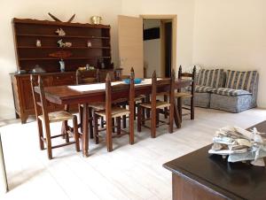 a living room with a wooden table and chairs at La Perla al mare 300mt from Perla Marina Beach in Santa Margherita di Pula +13 photos