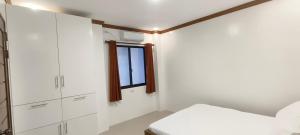 a bedroom with white cabinets and a window at Casa Victoria Pension House-Makra in Somosomo