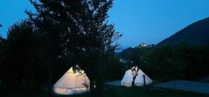 two white tents in a field at night at Glamping Cisnadioara in Cisnădioara +4 photos