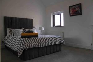 a bedroom with a bed with a black headboard and a window at Churchview in Cahersiveen