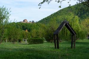 a sculpture in a field with a hill in the background at Glamping Cisnadioara in Cisnădioara